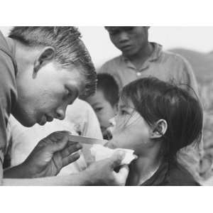 US Navy Corpsman Robert Miller Examining Girl in Village of Hao Hiep 